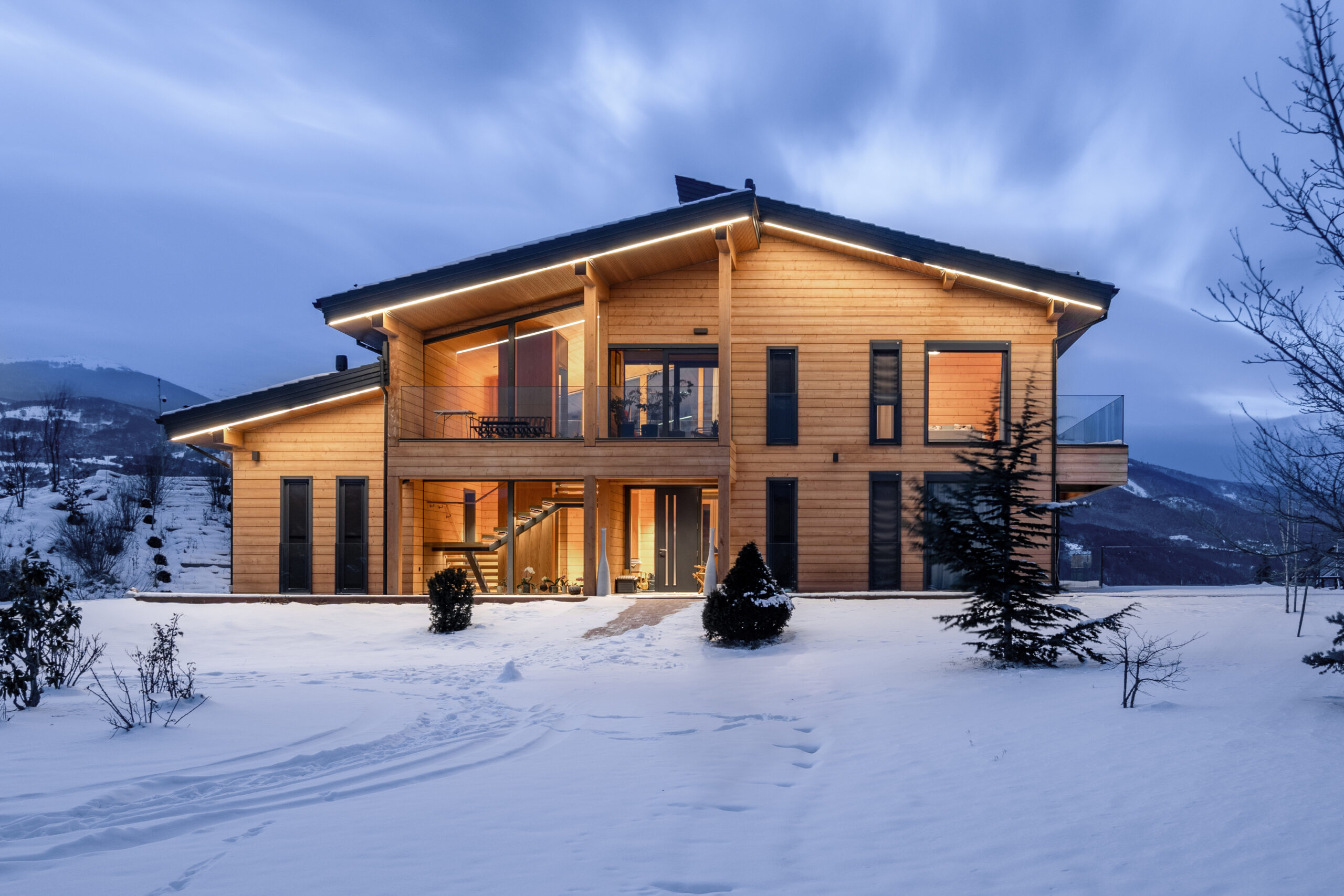The residence at dusk, framed by the surrounding hills